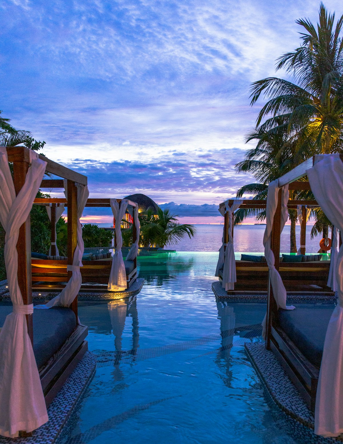 Luxury resort infinity pool with cabanas at sunset, romantic getaway